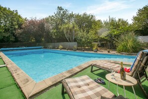 A swimming pool with a surrounding deck, lounge chairs, and a table with a bottle and glasses. - 1 Bed in Swanpool (oc-p45941) (Goldenbank)