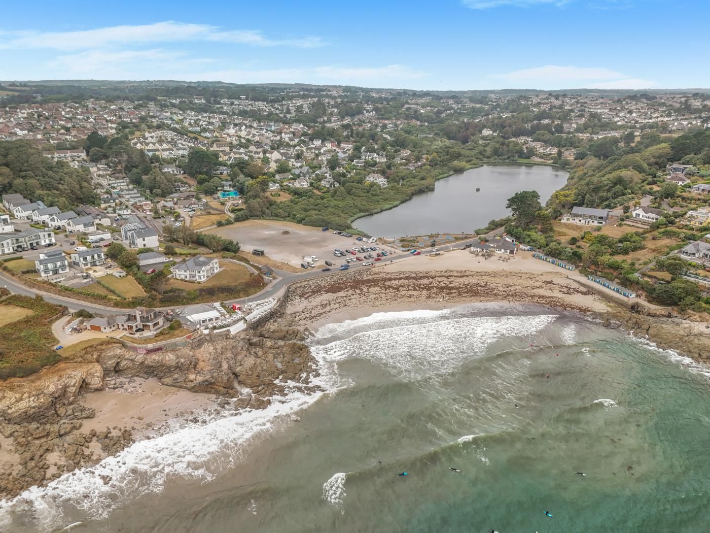 Vue aérienne d’une ville côtière avec des zones résidentielles, une plage et une rivière.