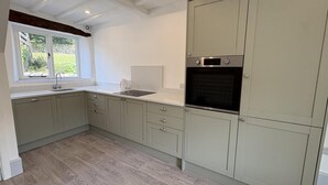 A kitchen with a built-in oven, a window with a view of greenery, and a wooden floor. - 3 Bed in Litton (oc-e45988) (Litton)