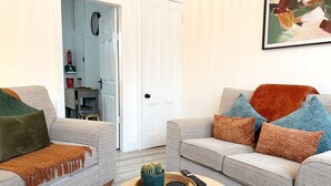 A living room with two sofas, a coffee table, and a door leading to a kitchen. - 3 Bed in Buxton (oc-p45951) (Buxton)