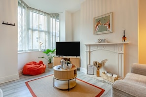 A living room with a television, a fireplace, and a painting on the wall. - 3 Bed in Buxton (oc-p45951) (Buxton)