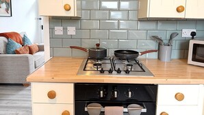 A kitchen with a gas stove, a microwave, and a cabinet with a light blue tiled backsplash. - 3 Bed in Buxton (oc-p45951) (Buxton)