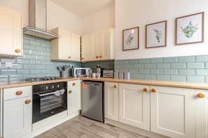 A modern kitchen with white cabinets, a gas stove, a microwave, and a dishwasher. - 3 Bed in Buxton (oc-p45951) (Buxton)