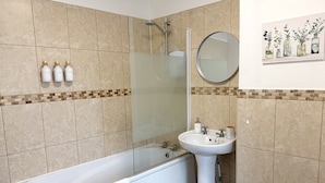 A bathroom with a bathtub, a glass-enclosed shower, a sink, and a mirror. - 3 Bed in Buxton (oc-p45951) (Buxton)