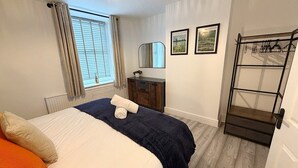 A bedroom with a bed, a dresser, a mirror, and a coat rack. - 3 Bed in Buxton (oc-p45951) (Buxton)
