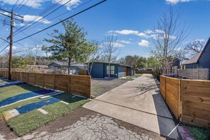 Un quartier résidentiel avec une allée pavée, des clôtures en bois et des maisons.