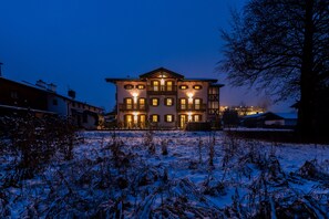 Un immeuble à plusieurs étages, doté d’une façade symétrique, de grandes fenêtres et d’une entrée centrale.