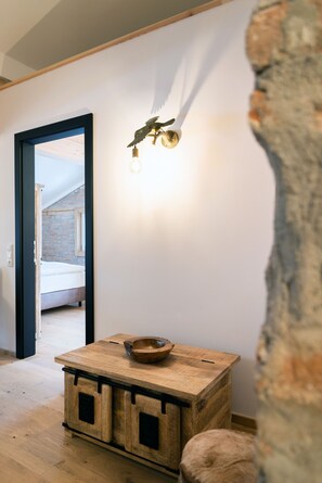 Une pièce avec une table en bois, un bol et un luminaire fixé au mur.