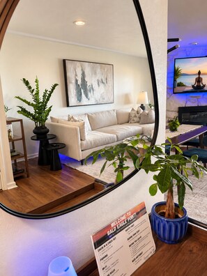 Ein Hotelzimmer mit einer Couch, einem Couchtisch, einem Fernseher und einem Schild mit Ein- und Auscheckzeiten.