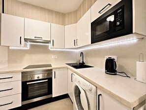 A modern kitchen with built-in appliances, including a microwave, oven, and dishwasher.