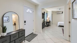 Ein Hotelzimmer mit einem Bett, einem Schreibtisch, einem Sessel, einer Kommode und einem Spiegel.