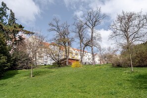 A grassy park area with trees and a building in the background. - Blueground | Prague 10, fully equipped & nr park (PRG-24) (Prague)