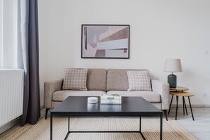 Ein modernes Wohnzimmer mit einer Couch, einem Couchtisch, einer Lampe und einem gerahmten abstrakten Gemälde.