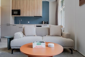 A modern living room with a sofa, a coffee table, and a book titled 'GREEN ARCHITECTURE 100 INTERIORS AROUND THE WORLD'. - Blueground | Nusle, view, furnished nr Vysehrad (PRG-70) (Prague)