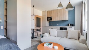 A compact living space with a sofa, a coffee table, a kitchen area, and a dining table. - Blueground | Nusle, view, furnished nr Vysehrad (PRG-70) (Prague)