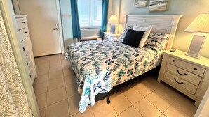 A bedroom with a bed, bedside tables, a nightstand, a window with curtains, and a door. - Oceanfront, steps to the surf!
Boardwalk attractions and the airport nearby! (Myrtle Beach)