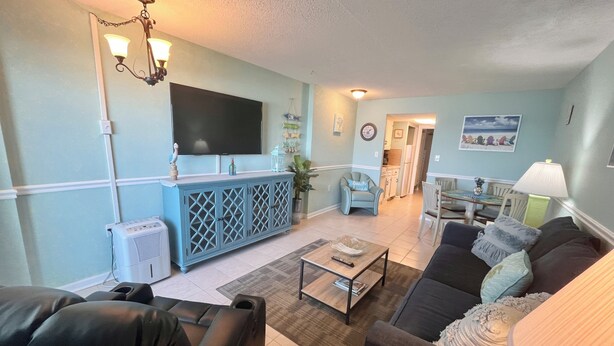A living room with a TV, a blue cabinet, a sofa, and a dining area in the background. - Oceanfront, steps to the surf!
Boardwalk attractions and the airport nearby! (Myrtle Beach)