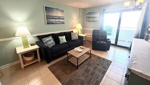 A living room with a sofa, armchairs, a coffee table, and a view of the sea through a large window. - Oceanfront, steps to the surf!
Boardwalk attractions and the airport nearby! (Myrtle Beach)