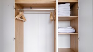 A wooden wardrobe with a hanging rod and shelves for folded clothes. - Blueground | Nusle, city view, nr Vysehrad (PRG-108) (Prague)