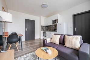 Ein modernes Wohnzimmer mit einer Couch, einem Couchtisch und einem Essbereich mit Stühlen.