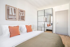 A modern bedroom with a large bed, a wardrobe, and two framed artworks on the wall. - Blueground | Žižkov, garden view, nr Vitkov (PRG-114) (Prague)