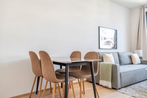 A modern living room with a dining table and chairs, a grey sofa, and a framed artwork on the wall. - Blueground | Žižkov, garden view, nr Vitkov (PRG-114) (Prague)