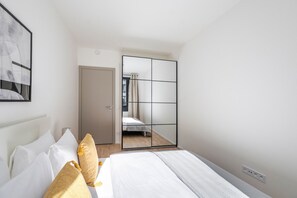 Ein Hotelzimmer mit Bett, Schrank und Spiegel.