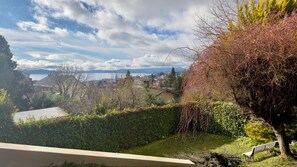 Ein Wohngebiet mit Blick auf ein Gewässer, Bäume und eine Bank.