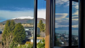 A view through a window of a coastal town with a mountain in the background. - El Coral - Lake View Apartment · Great Location in San Carlos de Bariloche (San Carlos de Bariloche)