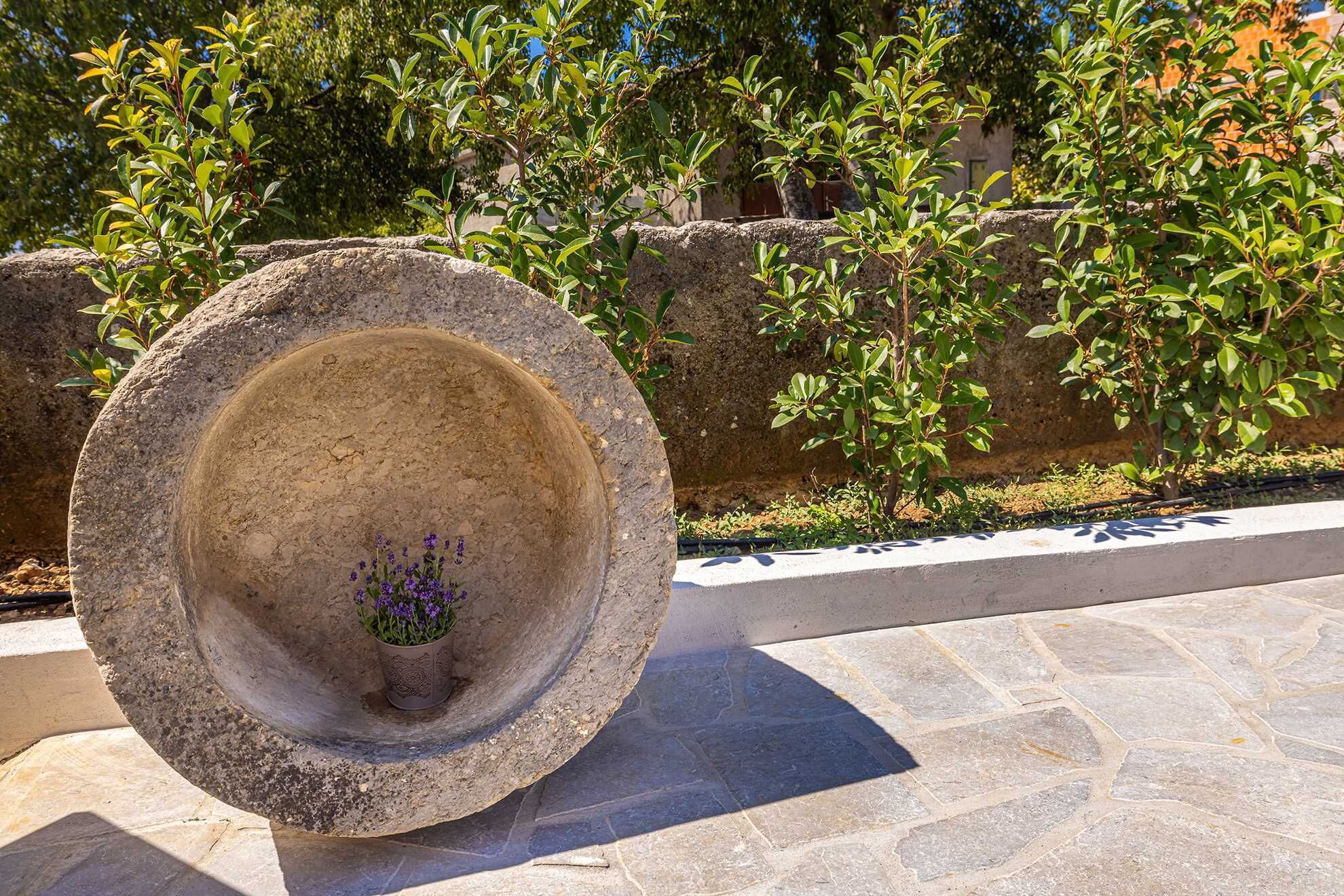 A stone planter with a small potted plant.