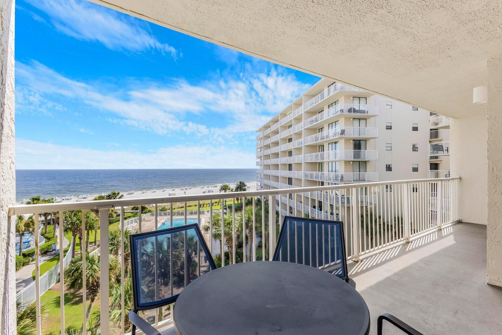 Un balcon avec vue sur l’océan et un bâtiment d’hôtel.