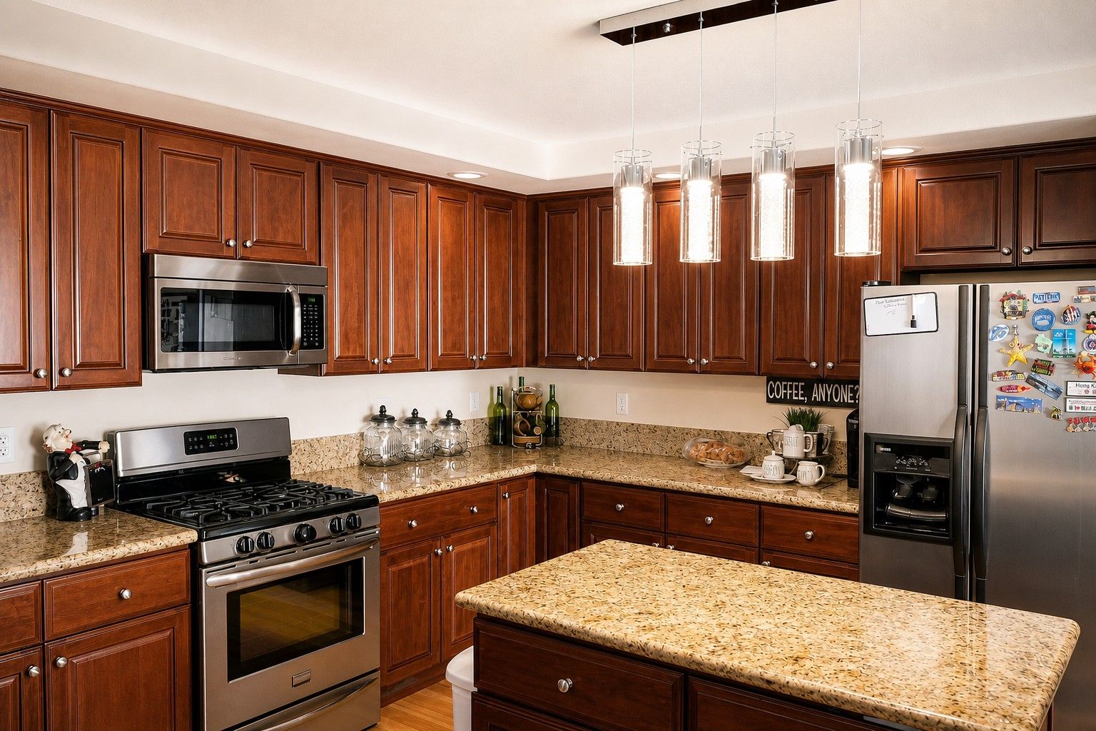 A modern kitchen with wooden cabinets, stainless steel appliances, granite countertops, and pendant lighting.