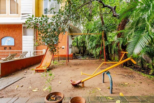 A playground with a slide, swings, and exercise equipment.