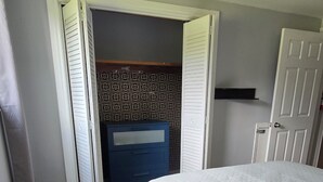 A bedroom with a bed, a ceiling fan, a wardrobe, and a door. - Modern comfort meets unique two level split suite. Family size and Pet Friendly (Cobourg)