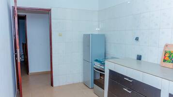 A kitchen with a stove, refrigerator, and cabinets.