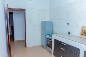 A kitchen with a stove, refrigerator, and cabinets.