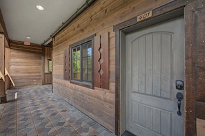 A wooden exterior with a number '401' above a door, a window with decorative trim, and a tiled floor. - Cloud Cap Condo 401 at South Grand Lodge | 2BR + Queen Loft, 3 Baths (Government Camp)