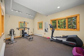 Ein Fitnessstudio mit Cardiogeräten, Krafttrainingsgeräten und einem Spiegel.