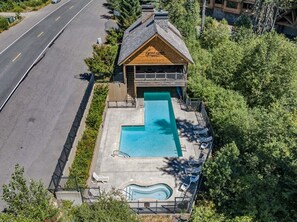 Ein Gebäude mit Schwimmbad, einer überdachten Terrasse und einer Straße im Hintergrund.