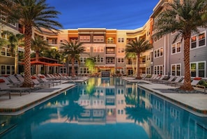 A hotel with a central swimming pool, multiple floors, and palm trees. - Upscale Living in Heart of Tampa, Courtyard Views (Tampa)