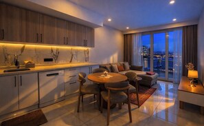 A modern living room with a dining area, a sofa set, and a view of the city at night. - Royal Grand Exculisive luxury apartment in charming Alanya (Alanya)