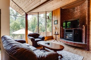 A cozy living room with a leather sofa, a wooden coffee table, and a fireplace.