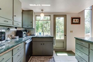A kitchen with a central island, a built-in oven, and a sink with a window above it. - 2BR + Loft Space | 5 Min to Autzen & River (Springfield)