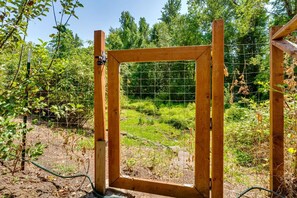 A wooden gate with a wire mesh, surrounded by greenery and trees. - 2BR + Loft Space | 5 Min to Autzen & River (Springfield)