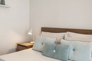 A neatly made bed with pillows and a bedside lamp. - Casa Burgues Mar & Lagoa - Private Pool (Óbidos)