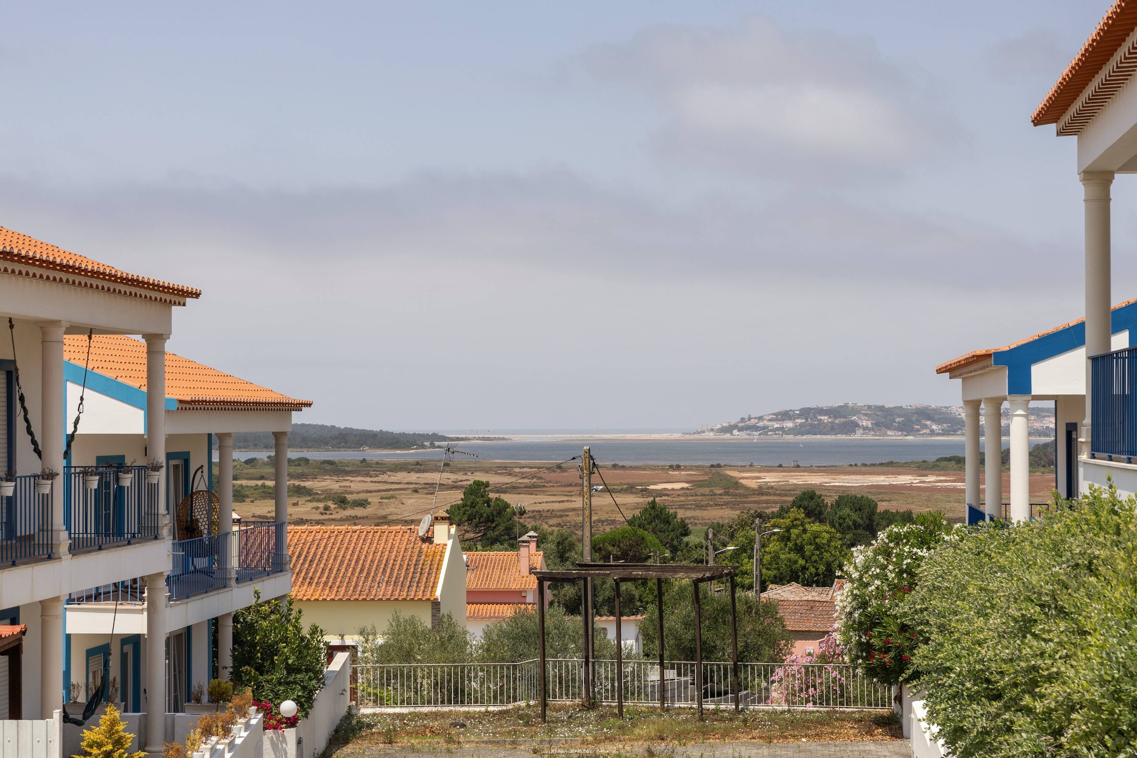 A coastal residential area with buildings featuring balconies and a view of the sea.