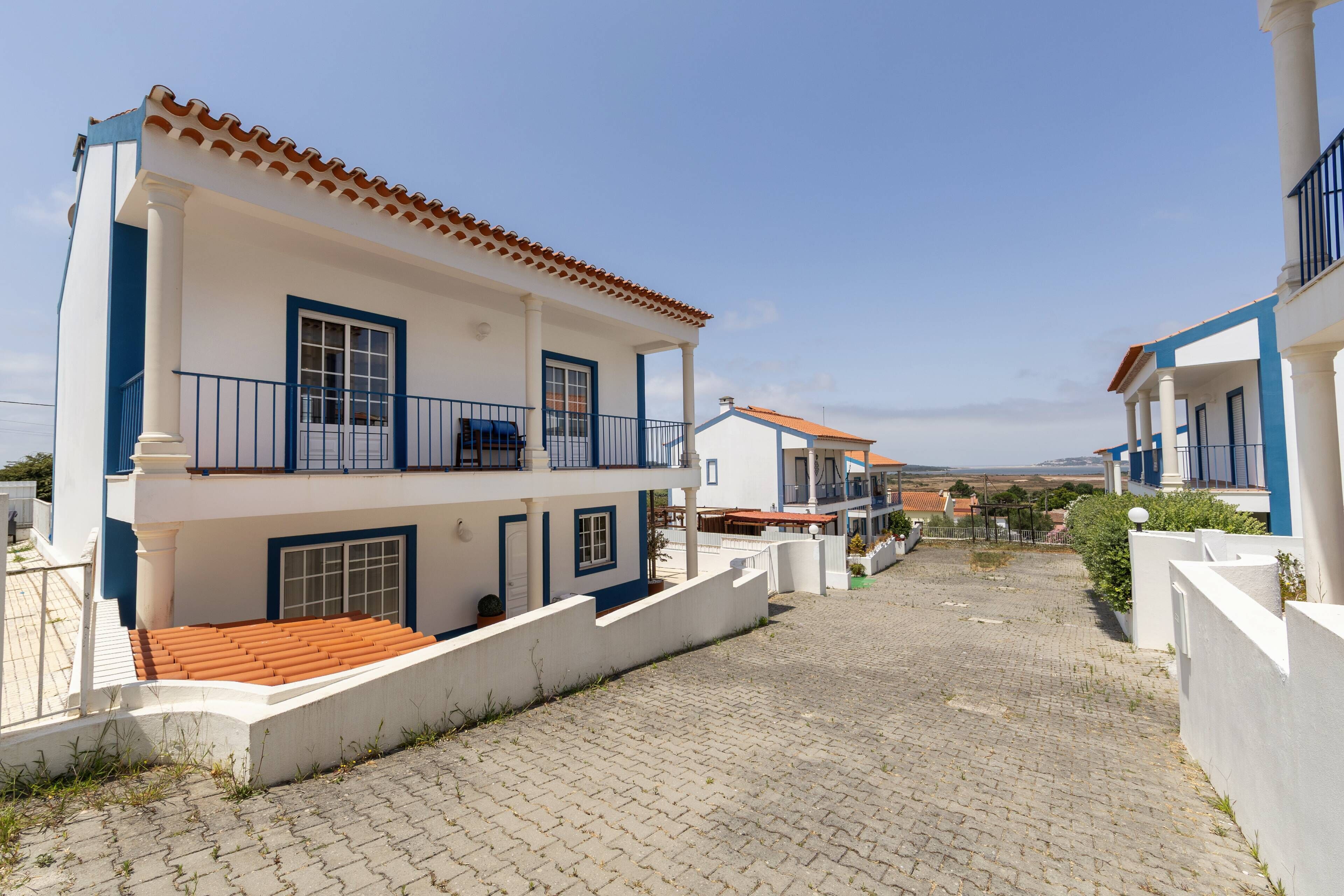 A two-story building with a tiled roof, white walls, and blue accents.