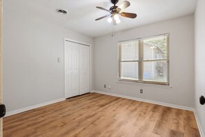 A room with a ceiling fan, a window with blinds, a white door, and hardwood flooring. - 3-bedroom house near the San Antonio Quarry (San Antonio)