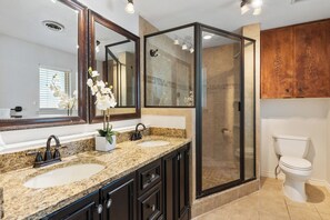 A bathroom with a double sink vanity, a glass-enclosed shower, and a toilet. - 3-bedroom house near the San Antonio Quarry (San Antonio)