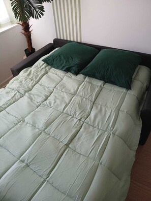 Ein Bett mit einer gesteppten Bettdecke und zwei Kissen.